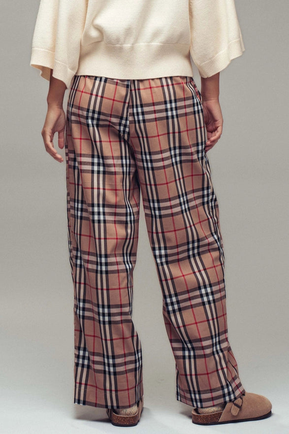 Plaid pants worn by a person on a plain background