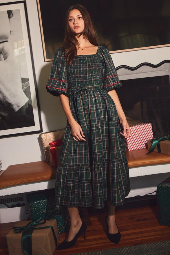 Woman wearing a green plaid midi dress with puff sleeves
