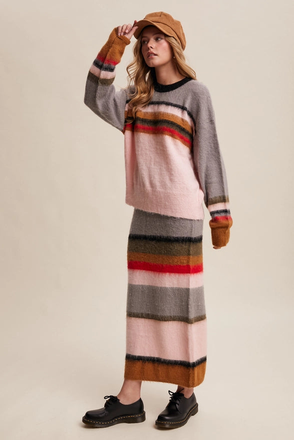 Woman wearing a striped sweater and skirt with a beige background