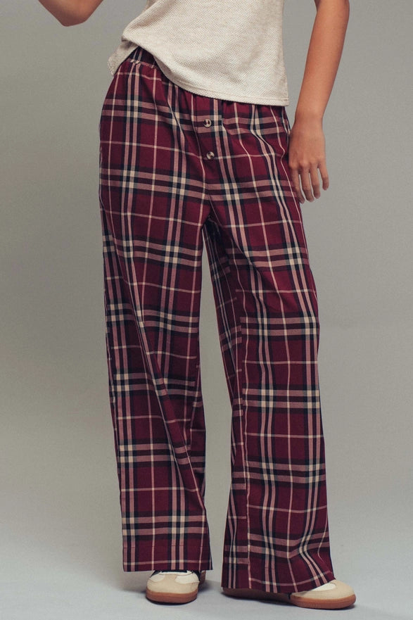 Plaid pants worn by a person on a plain background