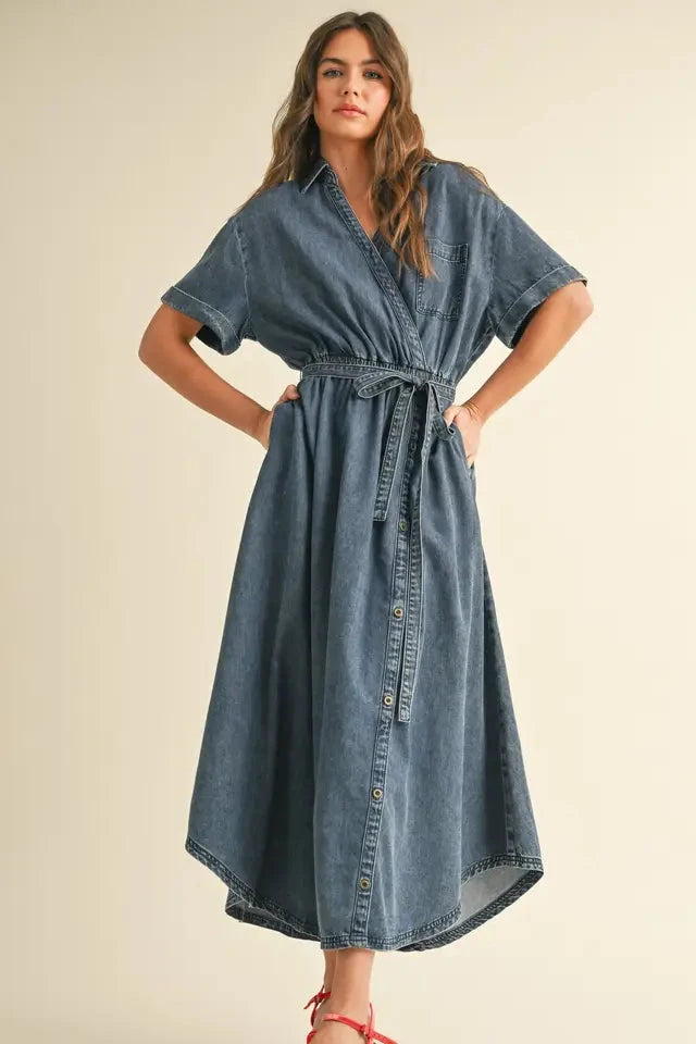 Woman wearing a denim dress against a plain background