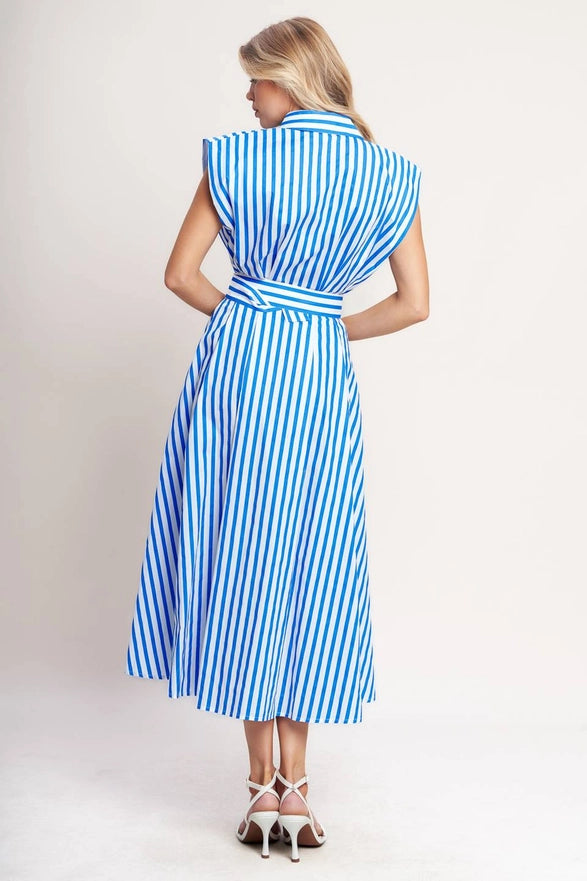 Woman wearing a blue and white striped dress against a plain background