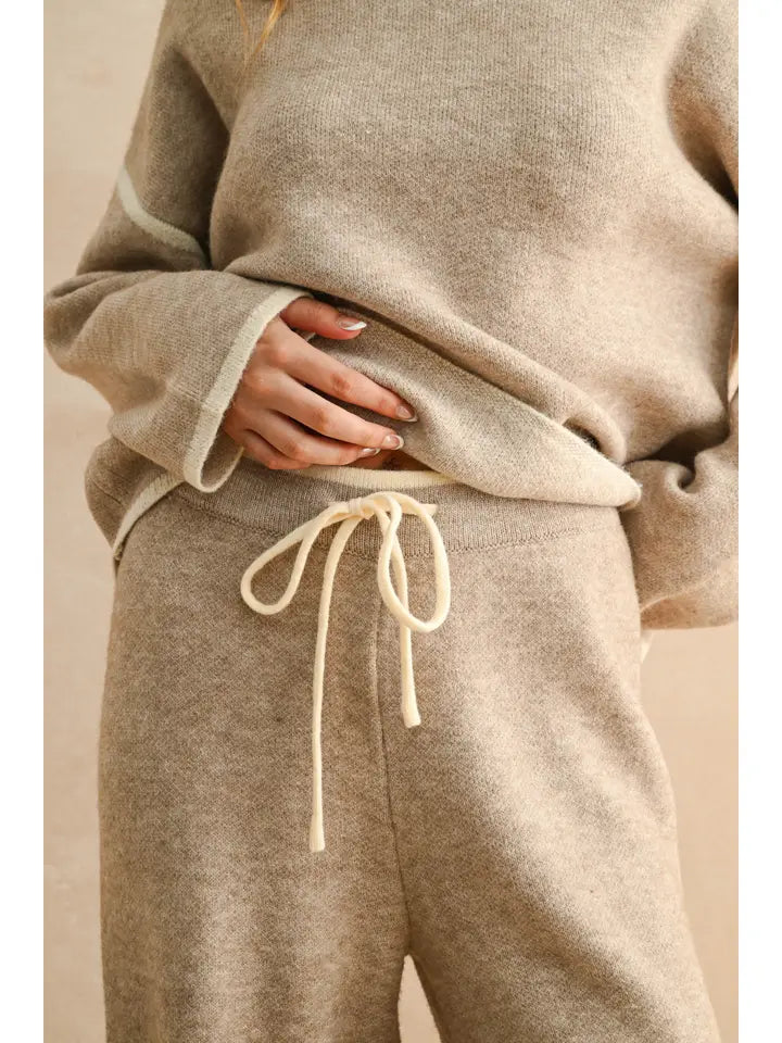 Beige sweater and pants set with a beige background