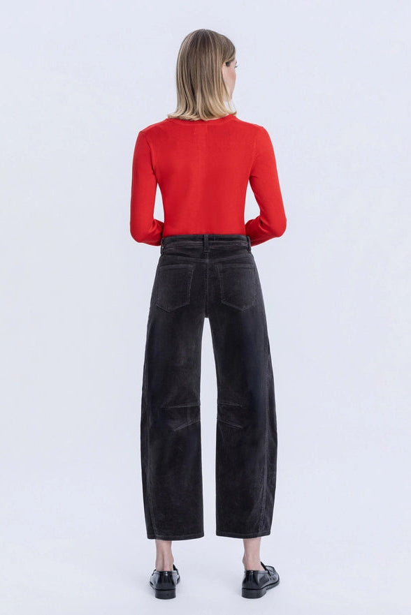 Person wearing a red top and black wide-leg pants on a white background