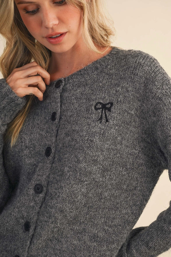 Gray cardigan with a black bow detail worn by a person