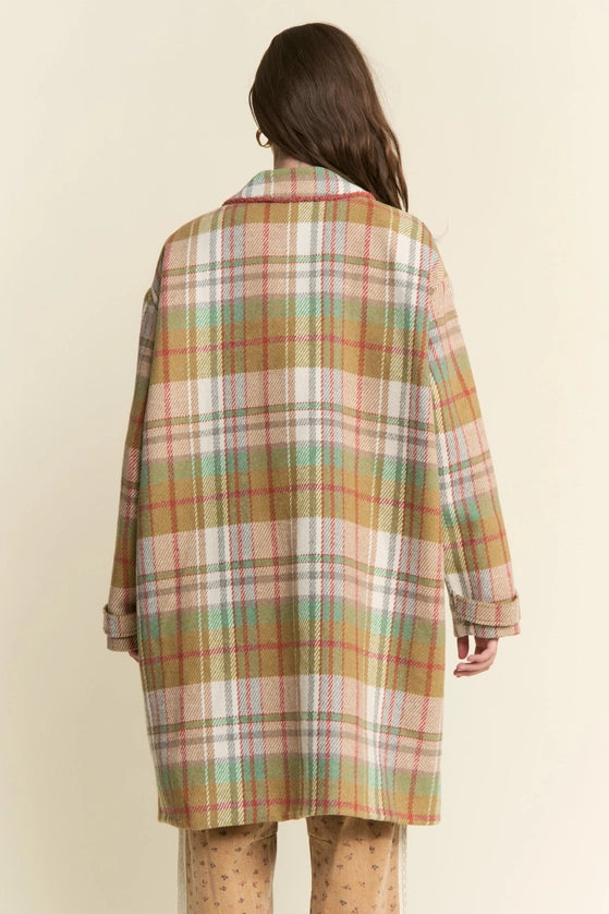 Person wearing a plaid coat with a neutral background