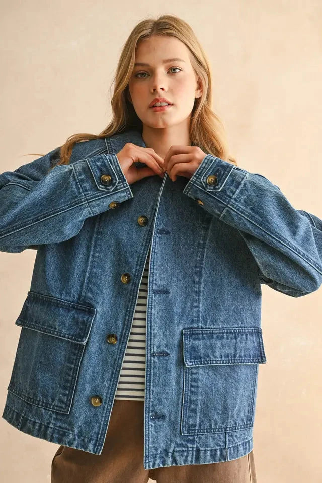 Woman wearing a blue denim jacket on a beige background