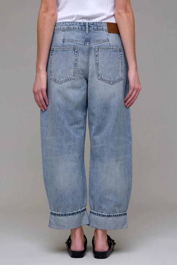 Light blue jeans worn by a person on a plain background