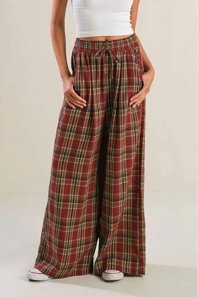 Person wearing red plaid pants on a plain background