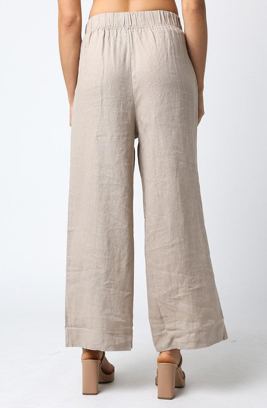 Beige wide-leg pants worn by a person on a white background