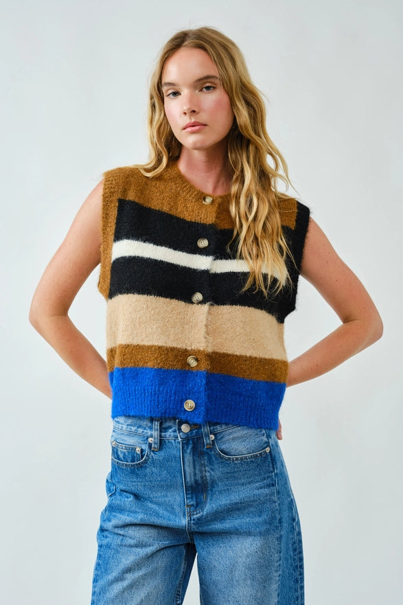 Woman wearing a sleeveless striped sweater vest with blue, brown, and beige colors on a plain background.