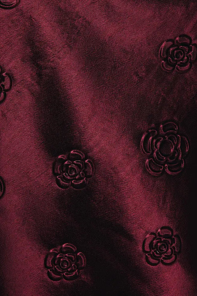 Close-up of dark red fabric with floral patterns