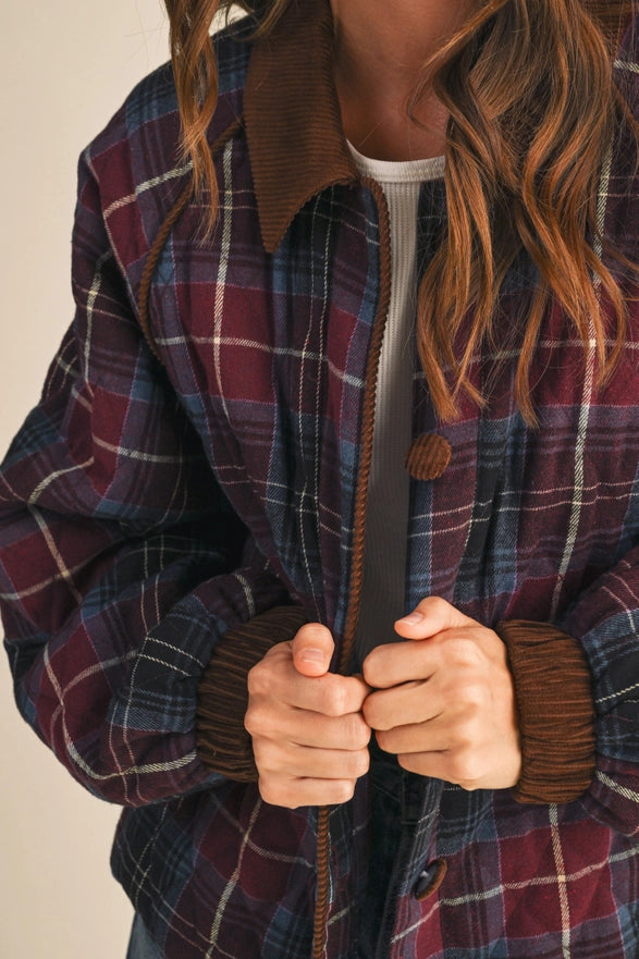 Person wearing a plaid jacket with a focus on the zipper and collar.
