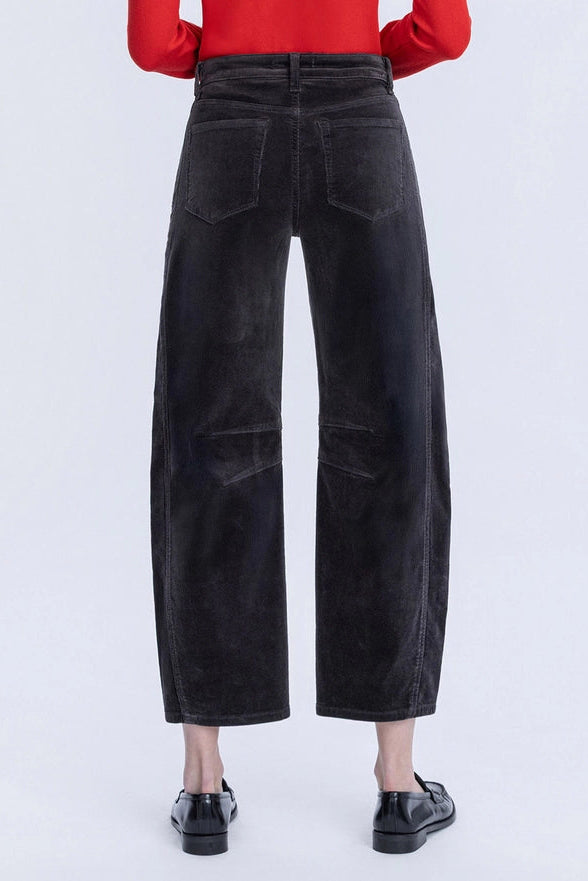 Black wide-leg pants worn with a red top on a white background