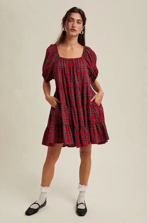 Woman wearing a red plaid dress on a beige background