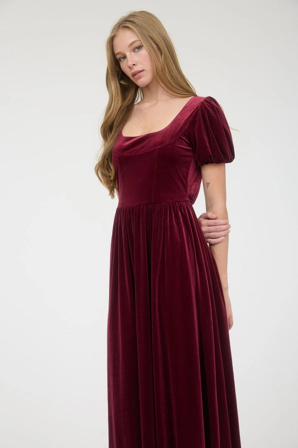 Woman wearing a burgundy velvet dress on a white background