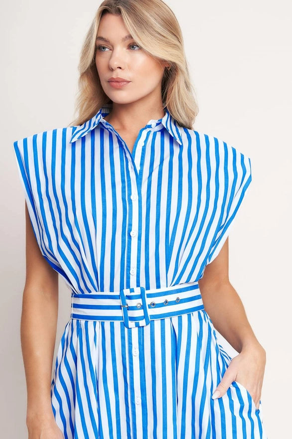 Woman wearing a blue and white striped dress against a plain background