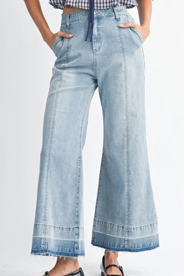 Light blue denim wide-leg pants worn by a person on a white background