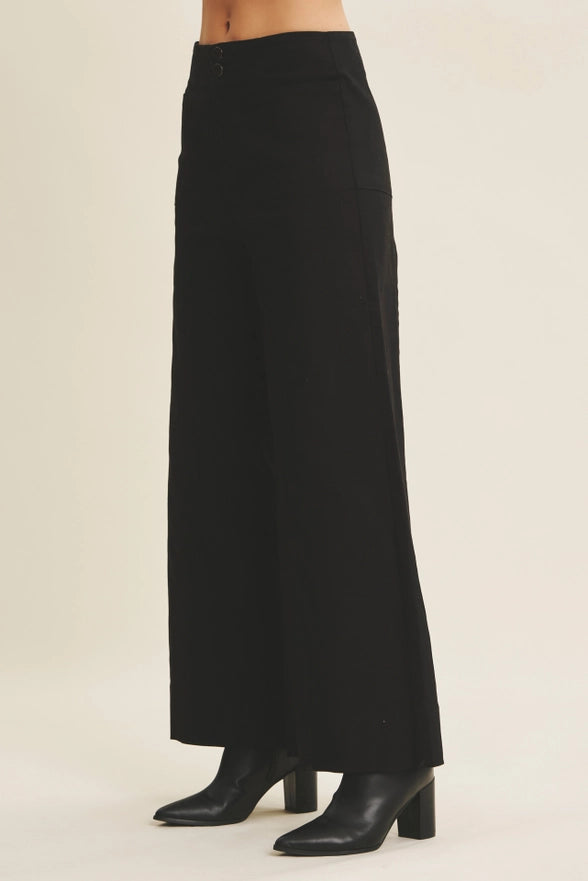 Black long skirt worn by a person on a beige background