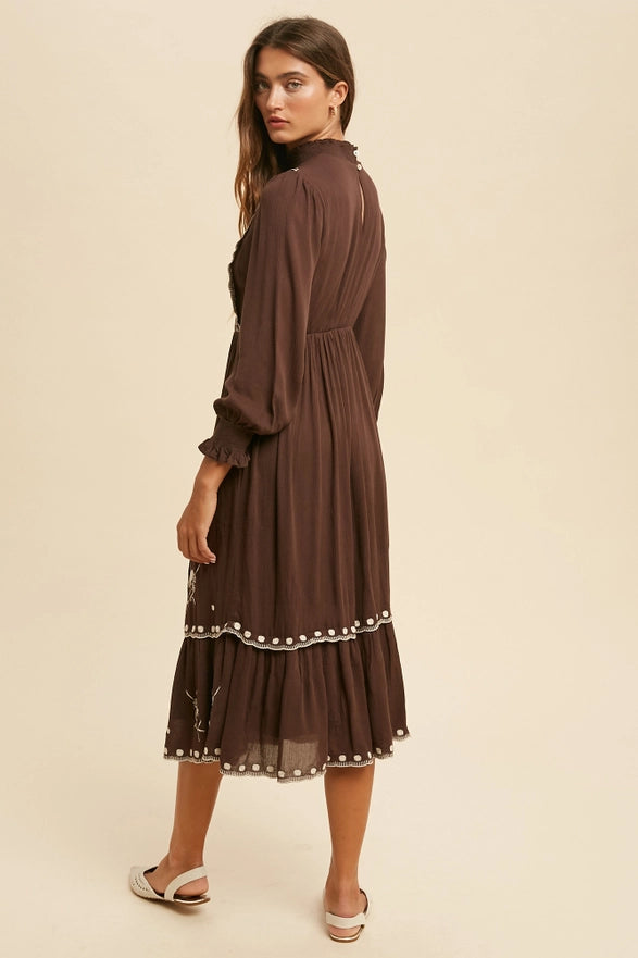 Woman wearing a brown dress with a textured pattern on a beige background
