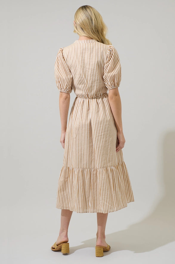 Woman wearing a beige and white striped dress on a plain background