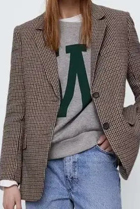 Person wearing a plaid blazer over a gray sweater with a green letter 'A' on a white background