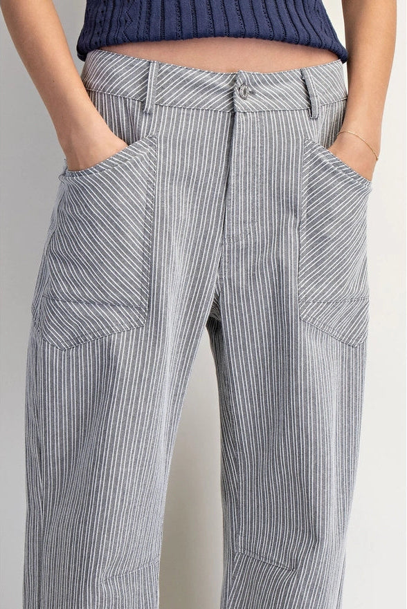 Person wearing gray striped pants with a white background