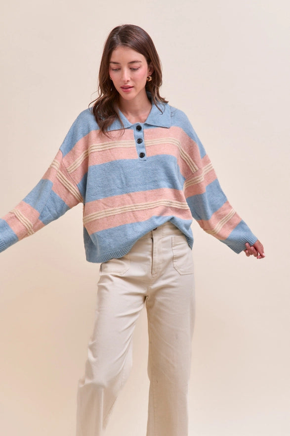 Woman wearing a striped poncho with a plain background