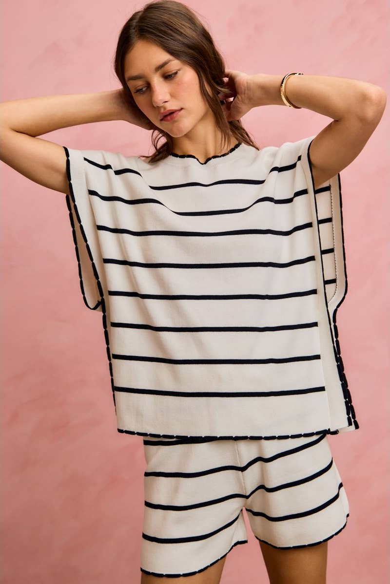 Woman wearing a black and white striped outfit against a pink background