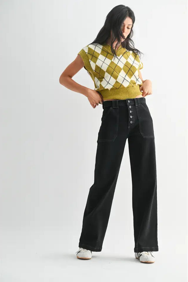 Woman wearing a yellow and white checkered top with black high-waisted jeans on a white background