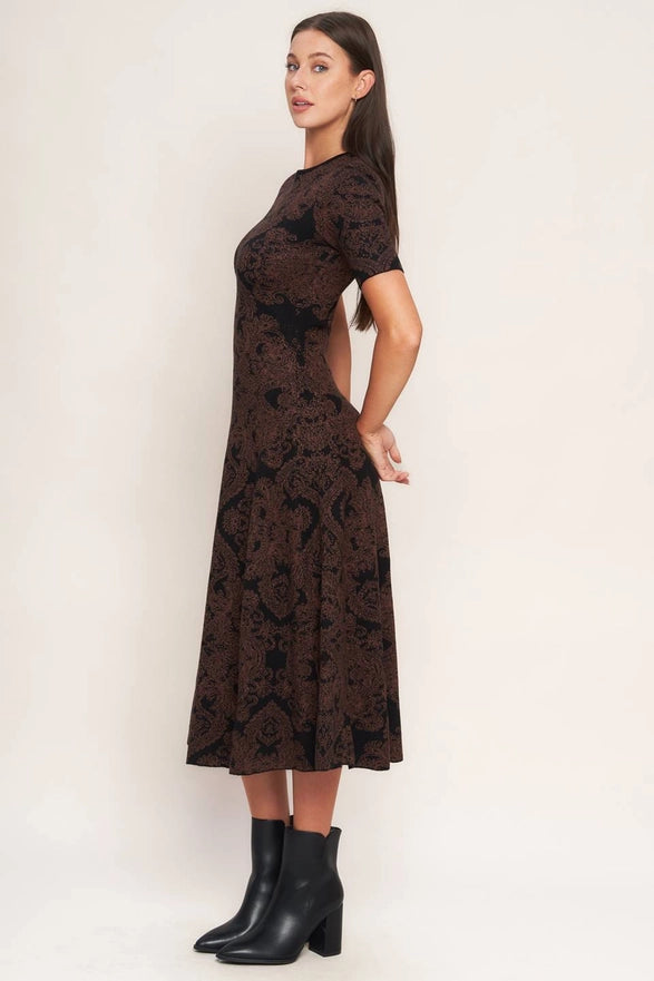 Woman wearing a black lace dress with cut-out design on a white background