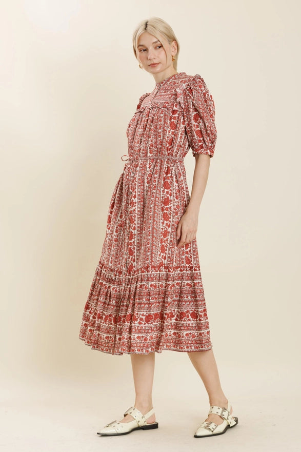 Woman wearing a red patterned dress on a beige background