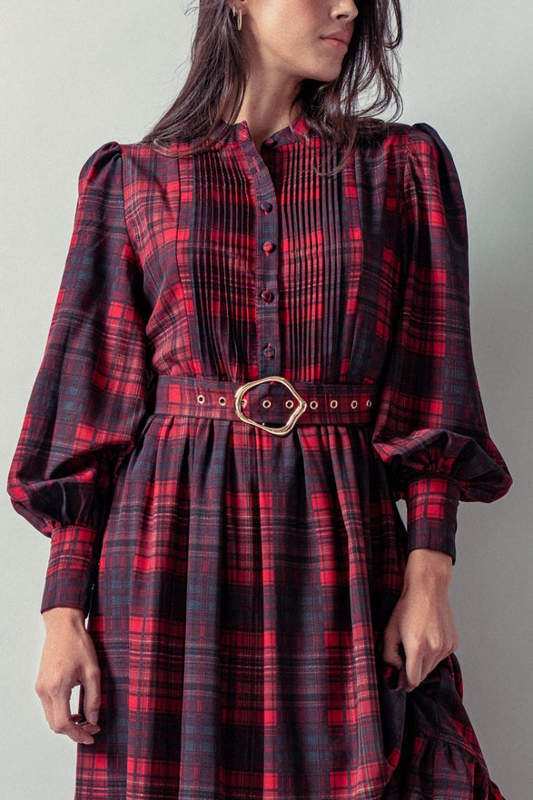 Woman wearing a red plaid maxi dress against a plain background.