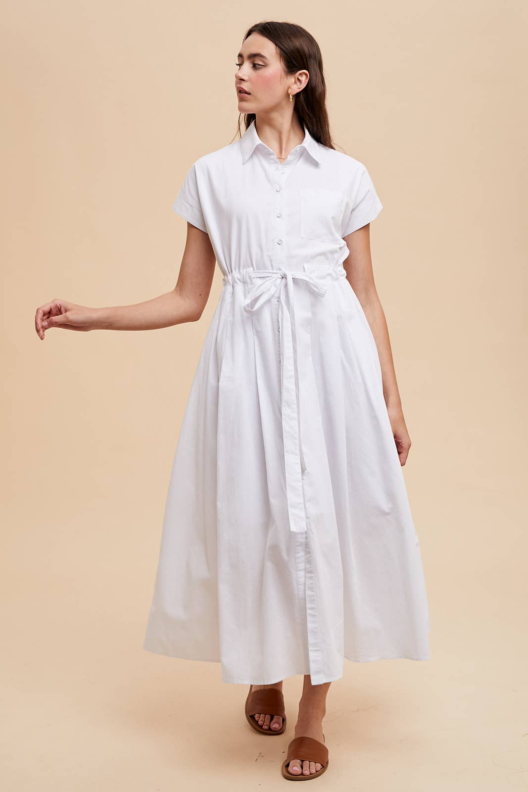 Woman wearing a white dress on a beige background