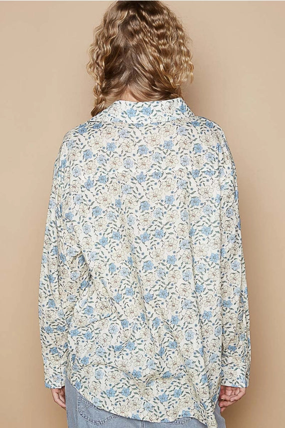 Person wearing a floral patterned shirt against a beige background