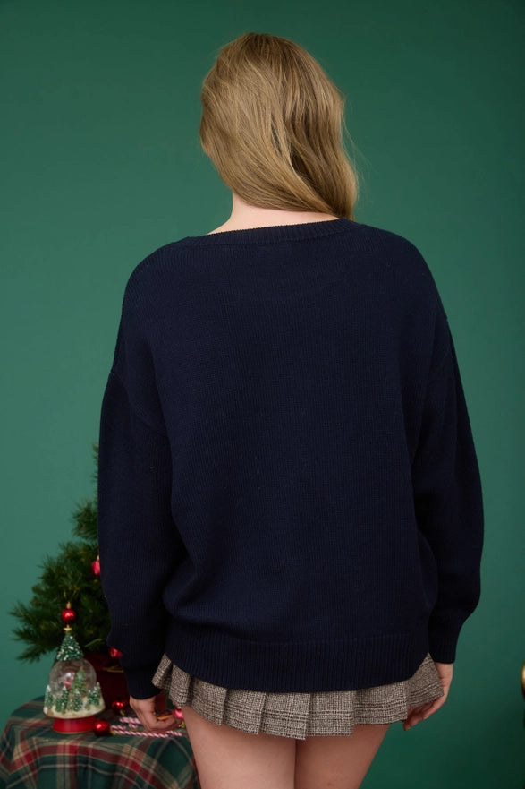 Person wearing a navy sweater with a green background