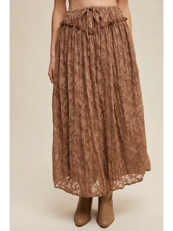 Brown patterned skirt worn by a person on a beige background