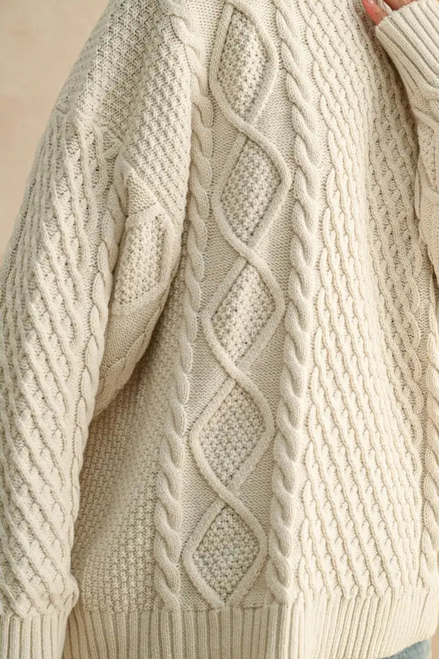 Close-up of a beige cable knit sweater