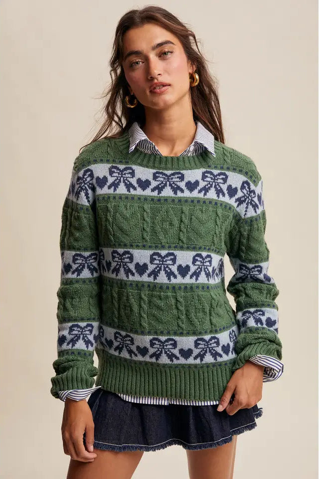 Woman wearing a green sweater with decorative patterns on a beige background