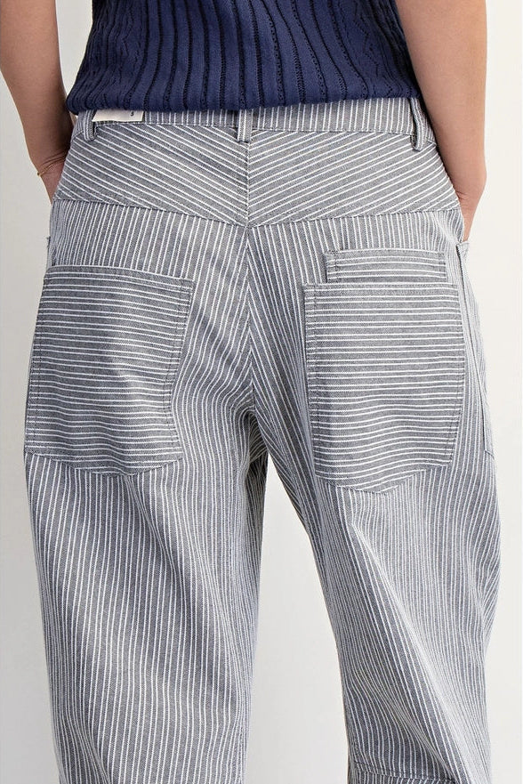 Person wearing blue striped pants and a navy sweater on a light background