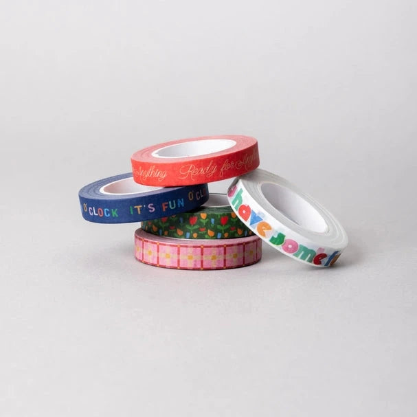 Five rolls of colorful washi tape with various designs on a light gray background