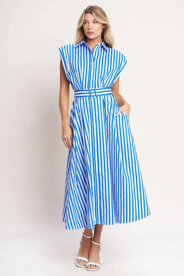 Woman wearing a blue and white striped dress against a plain background