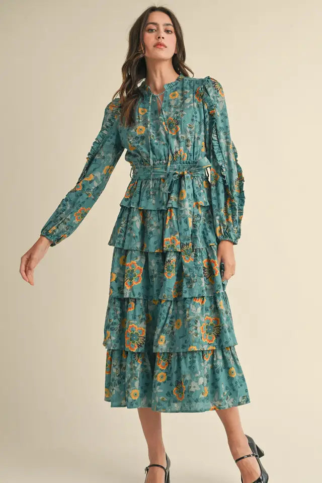 Woman wearing a teal floral dress on a beige background