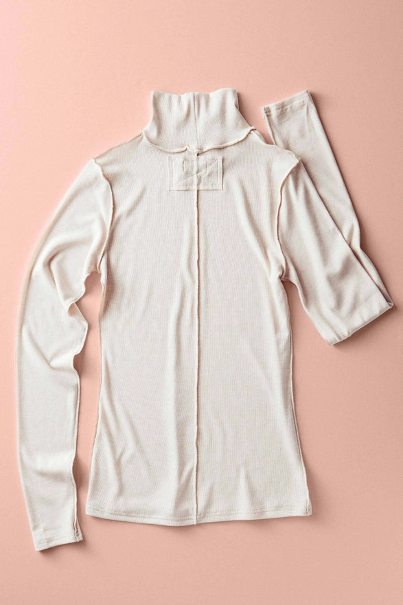White long-sleeve shirt with a high collar on a pink background
