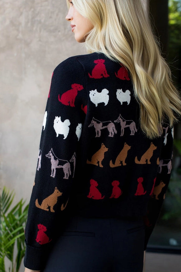 Person wearing a black sweater with colorful dog pattern against a neutral background
