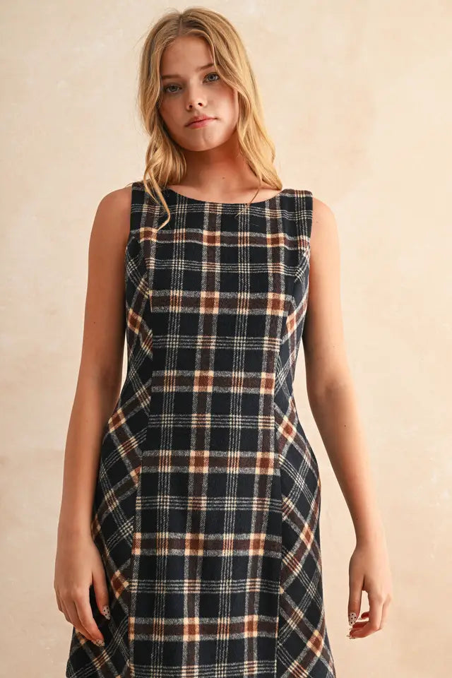 Woman wearing a plaid dress against a beige background