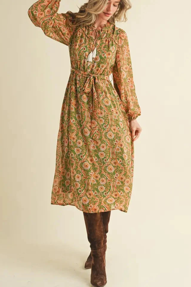 Woman wearing a floral dress with long sleeves on a beige background