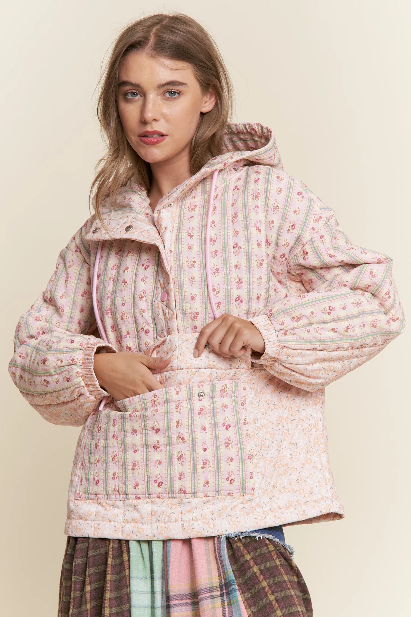 Woman wearing a floral quilted jacket on a beige background