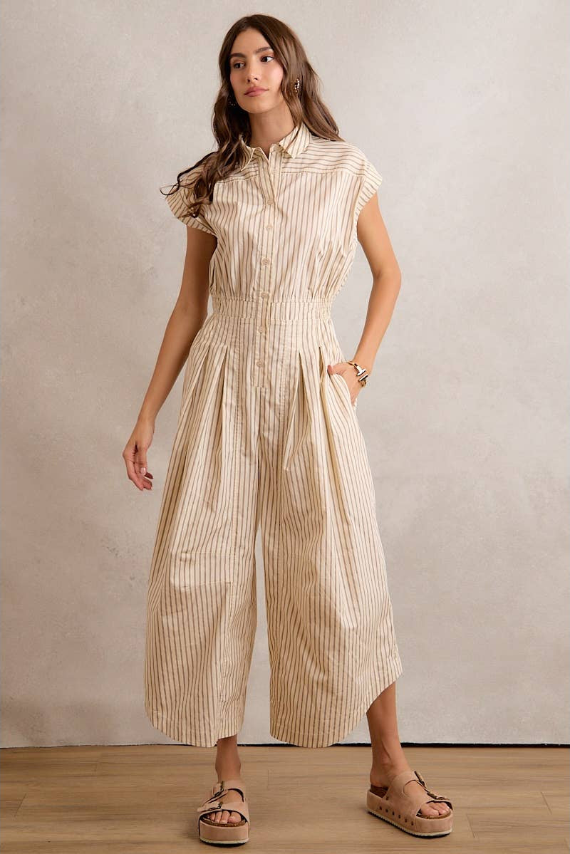 Woman wearing a beige and white striped dress against a plain background