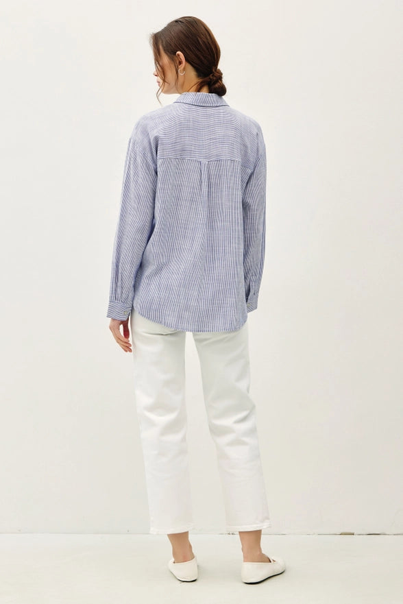 Person wearing a blue and white checkered shirt and white pants on a white background